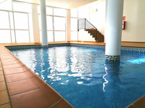 a swimming pool in a large building with columns at CASA DIEGO PUERTO BLANQUILLO in Frigiliana