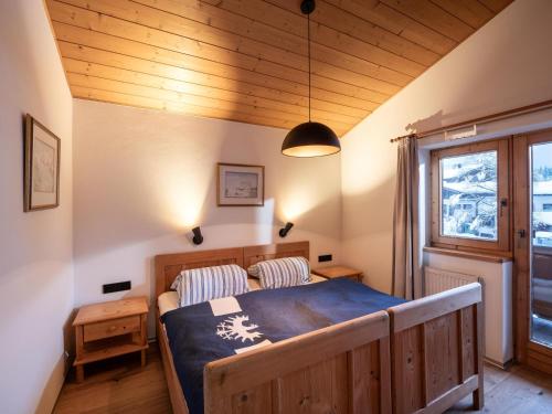 a bedroom with a wooden bed and a window at Ferienwohnung HOAMAT in Going