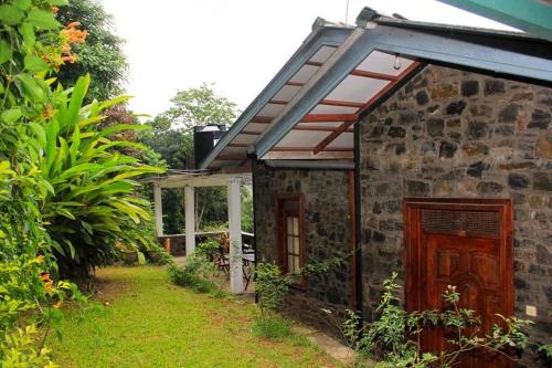 an outside view of a stone house with a garden at M country home in Mirahawatta