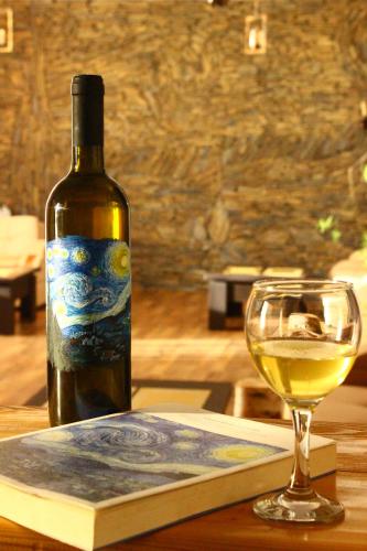 a bottle of wine and a glass of white wine at Hotel Starry Night in Stepantsminda