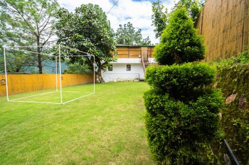 a yard with a net and a tennis court at The Golden Sunrise Hotel in Nainital