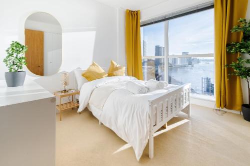ein weißes Schlafzimmer mit einem Bett und einem großen Fenster in der Unterkunft Riverview 2 Bedroom and 2 Bath Apartment in London