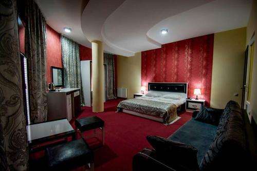 um quarto de hotel com uma cama e um sofá em BATONI em Tbilisi