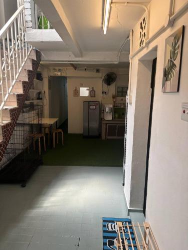 a room with a kitchen and a staircase with a refrigerator at SPOT ON 90898 Kasturi Alley Guest House & Cat Hotel in Melaka