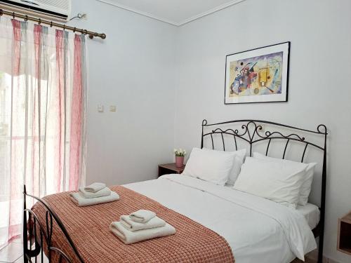 a bedroom with a bed with two towels on it at Bright apartment in Nea Palatia • Oropos in Néa Palátia