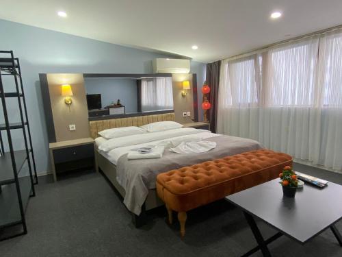 a bedroom with a large bed with a bench in it at Kadıköy Linda Hotel in Istanbul