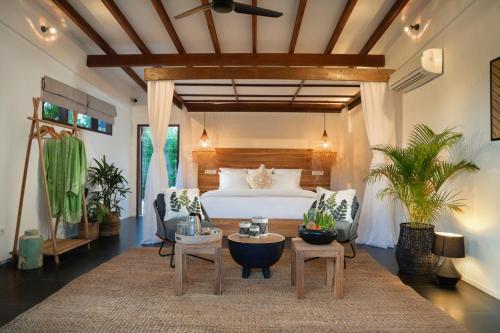 a bedroom with a bed and a table and chairs at Pondok Santi Estate in Gili Trawangan