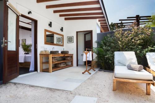 a patio with a white couch and a wooden door at Pondok Santi Estate in Gili Trawangan