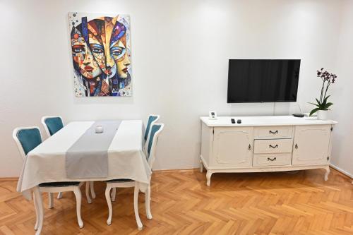 a dining room with a table and a painting on the wall at Apartman Felix in Laktaši