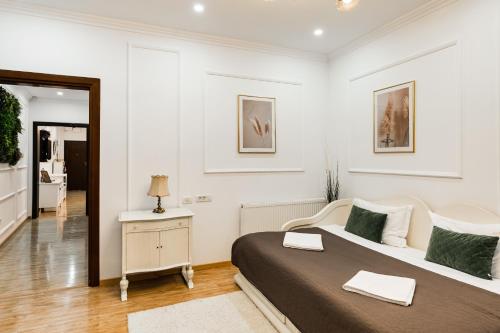ein weißes Schlafzimmer mit einem Bett und einem Spiegel in der Unterkunft Apollonia eState OLD TOWN BIG AND LUXURIOUS in Braşov
