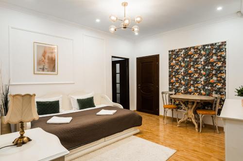 a bedroom with a large bed and a table at Apollonia eState OLD TOWN BIG AND LUXURIOUS in Braşov