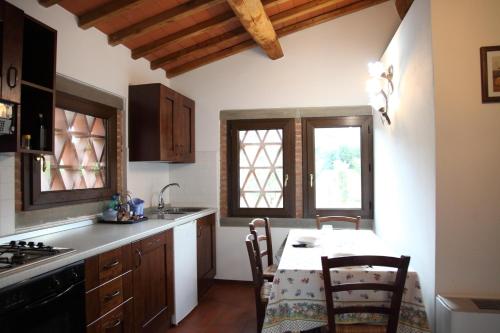 a kitchen with a table and chairs in a room at Tiberio in Loro Ciuffenna