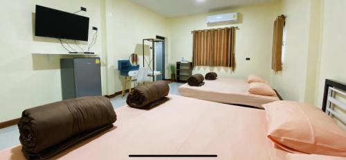 a room with two beds and a flat screen tv at Panutsaya Homestay in Wang Nam Khieo