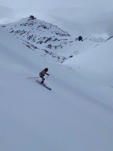 a person is skiing down a snow covered mountain at Gudauri Loft Apartment 416 in Gudauri
