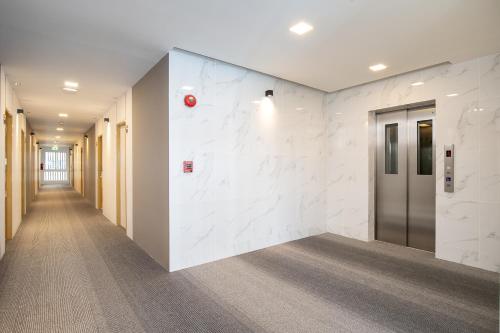 a corridor of an office with a white wall at Diya Hotel Bangkok in Amphoe Phra Khanong