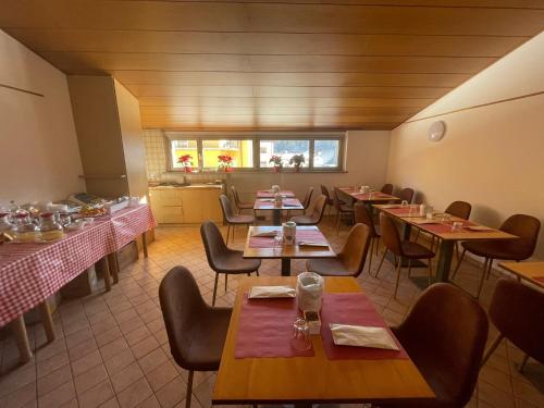 ein Restaurant mit Tischen und Stühlen in einem Zimmer in der Unterkunft Hotel Tarvis in Tarvis