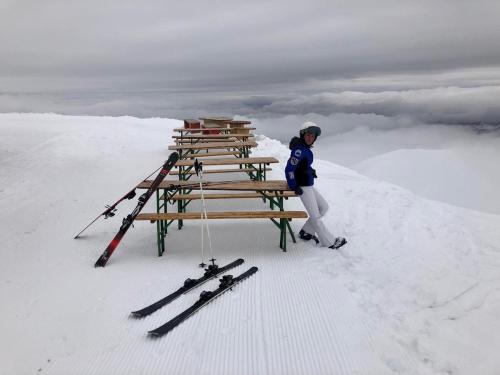 a woman standing on top of a table with skis in the snow at Gudauri Loft Apartment 416 in Gudauri