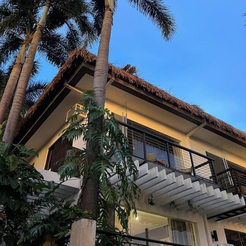 a building with palm trees in front of it at Villas by Eco Hotels in Mataasnakahoy