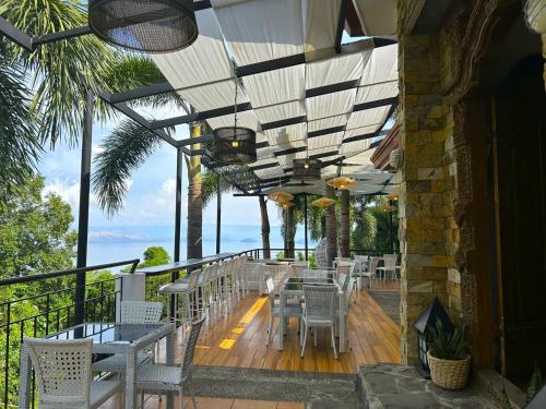 a restaurant with chairs and tables on a balcony at Villas by Eco Hotels in Mataasnakahoy