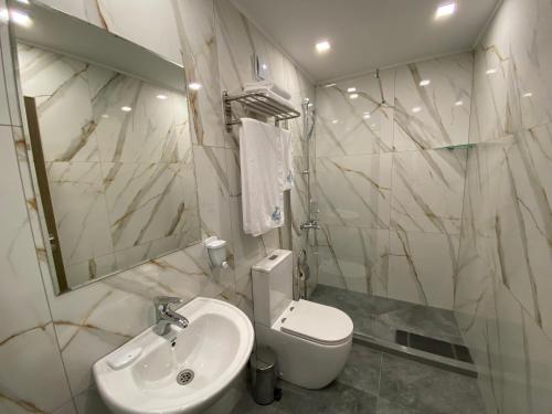 een witte badkamer met een wastafel en een toilet bij Комплекс Дунав in Ruse