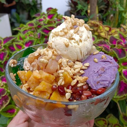 a bowl of fruit salad with ice cream and nuts at Villas by Eco Hotels in Mataasnakahoy