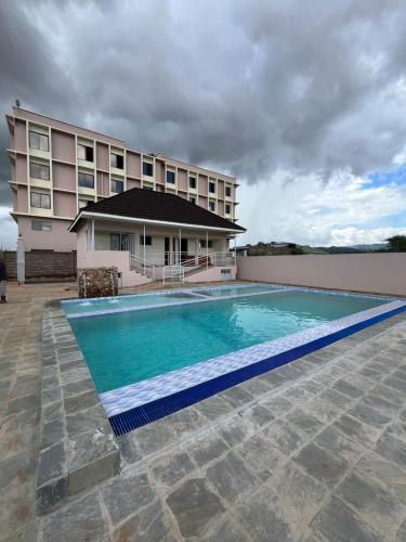 a hotel with a swimming pool in front of a building at THE AVID HOTEL in Voi