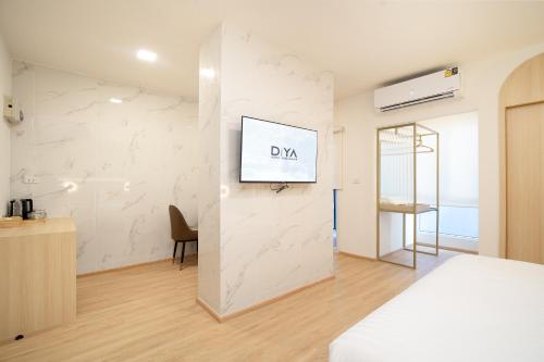 a bedroom with a bed and a tv on a wall at Diya Hotel Bangkok in Amphoe Phra Khanong