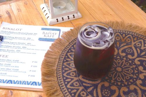 een drankje op een bord naast een menu bij Kaliraya Surf Kamp by Eco Hotel Laguna in Cavinti
