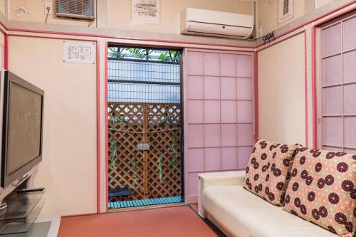 a living room with a couch and a window at I LOVE HANEDA in Tokyo