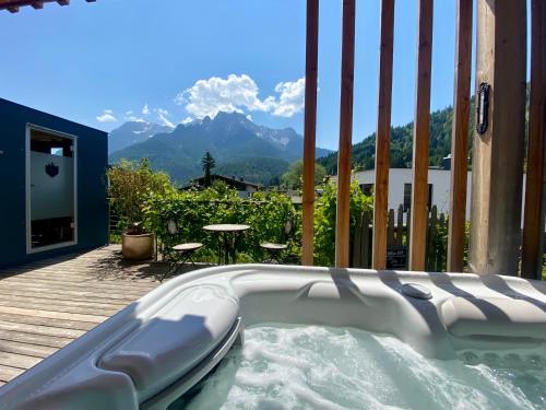 a hot tub on a deck with a view of mountains at Alpegg Chalets in Waidring