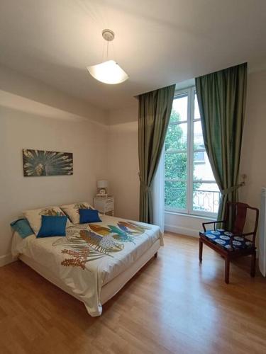 une chambre avec un lit, une chaise et une fenêtre dans l'établissement Hôtel le Remigny XVII siècle, à Nevers