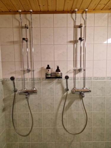 um chuveiro numa casa de banho com 2 cabeças de chuveiro em Levi -Sky Slope Apartment - 3 Bedrooms em Sirkka