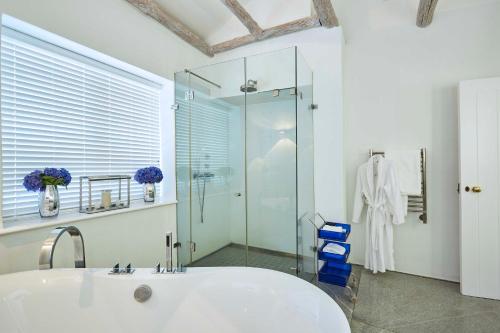 a bathroom with a tub and a glass shower at Allèe Bleue Wine Estate in Simondium