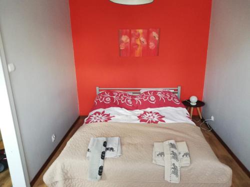 ein Schlafzimmer mit einem Bett mit einer roten Wand in der Unterkunft Emilka in Suwałki