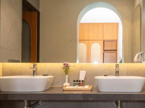 een badkamer met 2 wastafels en een grote spiegel bij Calangute Towers - AM Hotel Kollection in Calangute