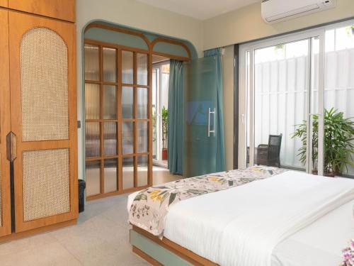 a bedroom with a bed and a large window at Calangute Towers - AM Hotel Kollection in Calangute