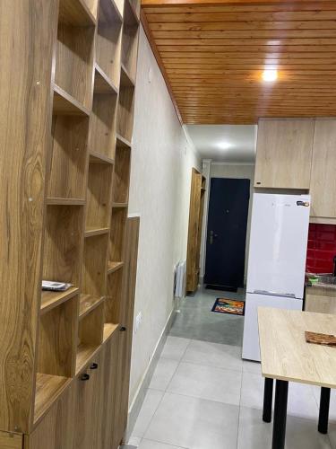 a kitchen with wooden shelves and a white refrigerator at Garage Hotel - Old Tbilisi in Tbilisi City