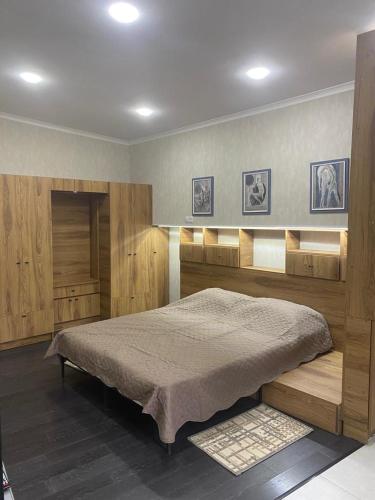 a bedroom with a large bed with wooden cabinets at Garage Hotel - Old Tbilisi in Tbilisi City