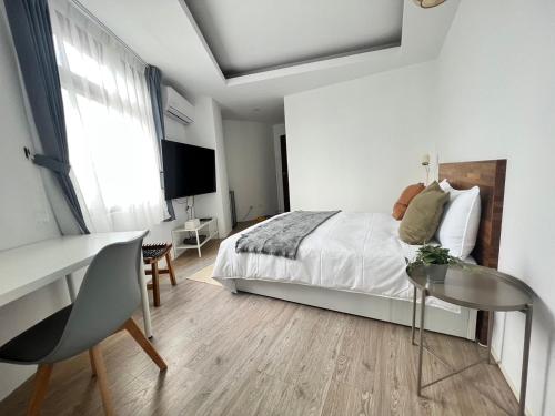a bedroom with a bed and a desk and a table at 樓梯旅宿-東大門夜市旁-可包棟 in Hualien City
