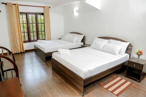1 dormitorio con 2 camas, mesa y sillas en Villa Kengalle, en Kandy
