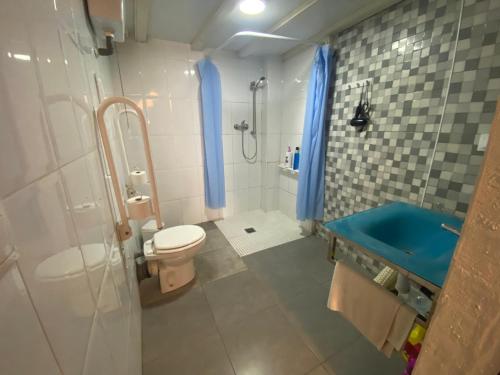 uma casa de banho com um WC e um chuveiro com cortinas azuis em better Oh! em Valência