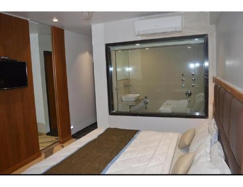 bagno con letto, lavandino e specchio di Hotel Relax Inn, Surat, Gujarat a Surat