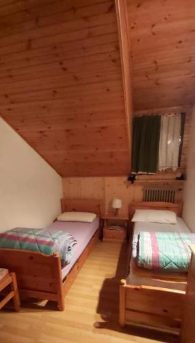 Habitación con 2 camas en una cabaña de madera en Appartamento a Francolini, en Folgaria
