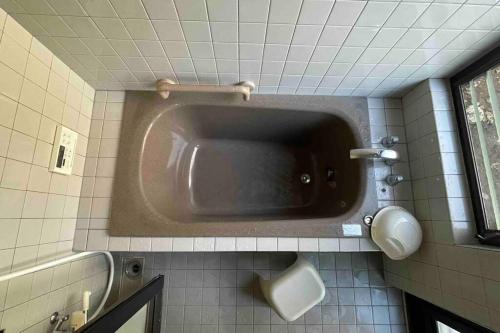 a bathroom with a sink in a tiled wall at 庭付き和モダン平屋の一棟貸し 居庵 iori-ori 小さな森に住む in Shiigi
