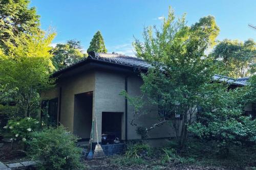 a small house in the middle of trees at 庭付き和モダン平屋の一棟貸し 居庵 iori-ori 小さな森に住む in Shiigi