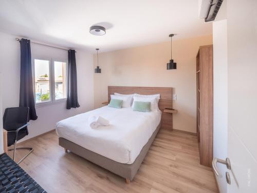 ein Schlafzimmer mit einem großen weißen Bett und einem Stuhl in der Unterkunft Le Mâconnais Guest House in Vinzelles