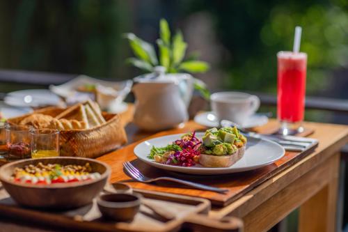a wooden table with a plate of food on it at The Sankara Resort & Spa in Ubud