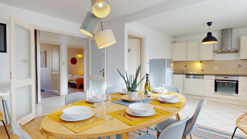 - une salle à manger et une cuisine avec une table et des chaises en bois dans l'établissement Elegance, appartement 6 pers 1 parking, à Colmar