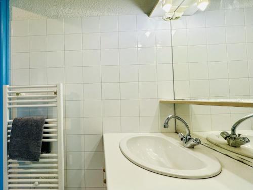 une salle de bain blanche avec un lavabo et un miroir dans l'établissement Studio avec vue imprenable sur le port de plaisance 4 pers, à Les Sables-dʼOlonne