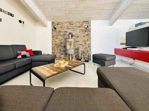 a living room with a couch and a table at Superbe villa avec piscine située à 2 km de la Grande Plage des Sables in Les Sables-d'Olonne